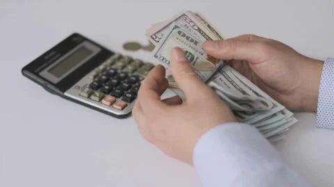 Fingers counting a stack of dollar bills on a white background. hands counting a Stock-Footage 336261133