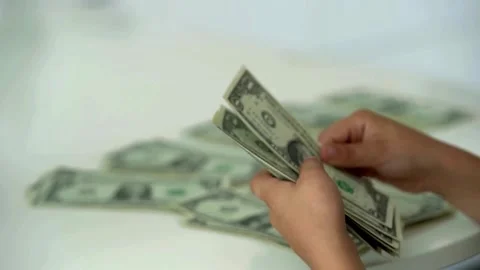 Fingers counting a stack of dollar bills on a white background. hands counting a Stock-Footage 336261155