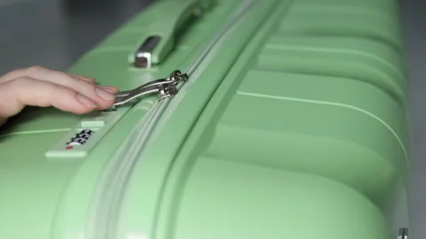 Fingers deftly unlock the combination lock on the suitcase. Stock Footage 314344143