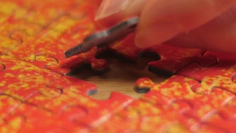 Fingers Finalizing Orange Jigsaw Puzzle Stock Footage 148540367