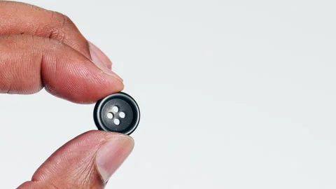 Fingers Holding Black Button in a macro shot Video stock 248704315