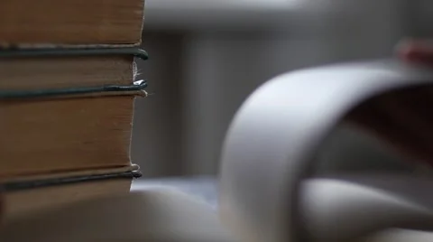 Fingers leafing reading a real paper book at the table in slow motion Stock Footage 61783658