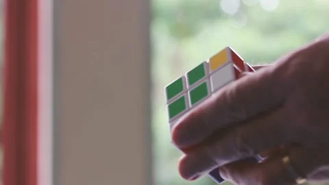 Fingers Manipulating Rubik Cube With Bokeh Background Stock Footage 123814468