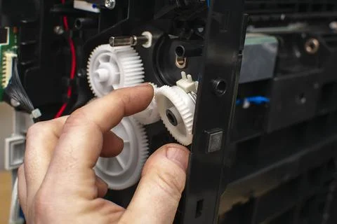 Fingers of a master pull out, take out the gear Stock Photos
