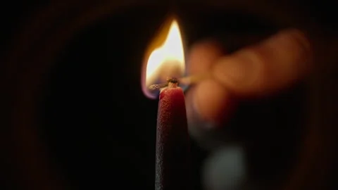 Fingers match sparking candle using match black background closeup. Bright flame Stock Footage 332505874