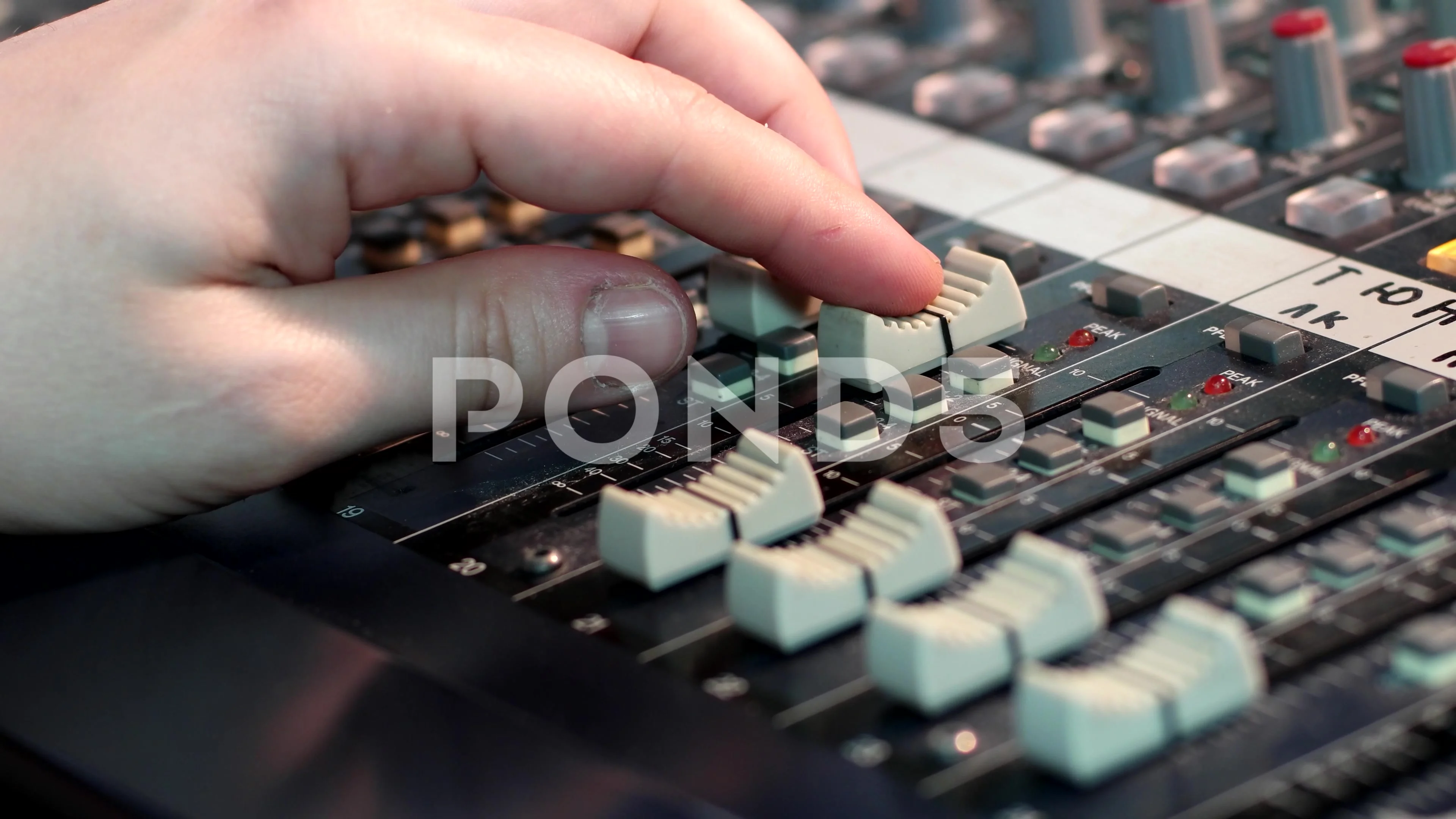 Male Finger on Audio Mixer Slider Button. Focus Selected on the