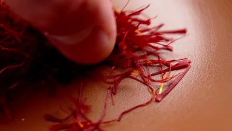 Fingers pick up premium saffron threads Stock Footage 338343650
