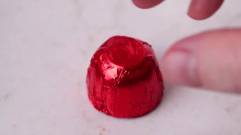 Fingers picking red chocolate candy on white marble table in slow motion Stock Footage 306412498