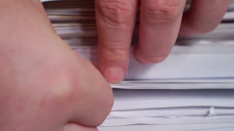 Fingers plucking through a large stack of paper documents.Close-up. Stock Footage 143971675