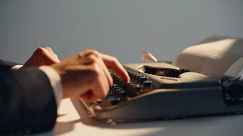 Fingers pressing old-fashioned keys in sunlight closeup. Writer developing novel Stock Footage 332342579