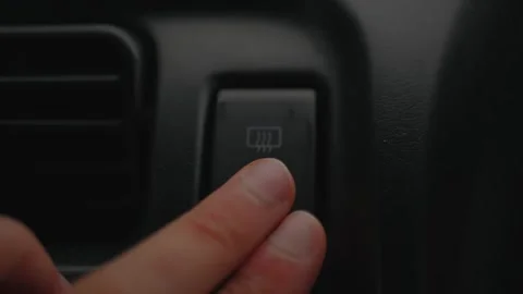 Fingers pressing the rear defroster button inside a vehicle... Stock Footage 339101314