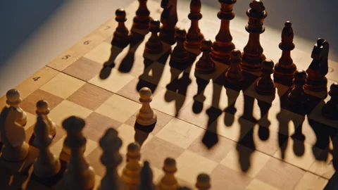 Fingers pushing initial figure on patterned board with shadows. Player starting Video stock 332336988