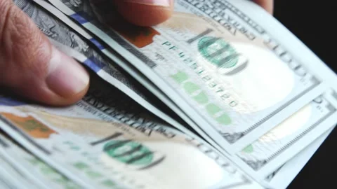 Fingers scroll and shift new 100 dollar bills. Shopping for cash. Payment of exp Stock Footage 232992940