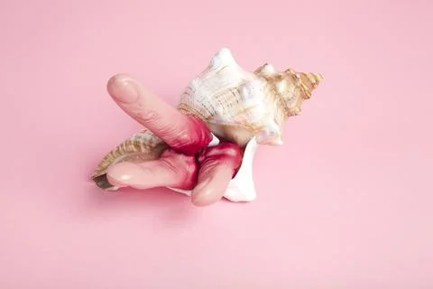 Fingers snatched from a corpse emerging from a conch shell Stock Photos