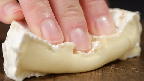 Fingers Squeeze a Piece of Soft Cheese camembert or brie Stock Footage 129078488