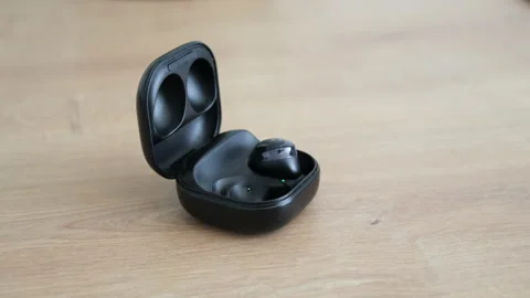 Fingers take black small mobile wireless headphones from black case for storing Stock Footage 224467720