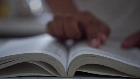 Fingers tracing lines while reading an open book. 스톡 동영상 347685756