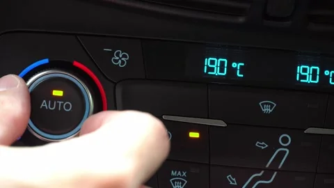Fingers turn toggle switch of car air conditioner decreasing temperature in Stock Footage 247713526