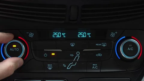 Fingers turn toggle switch of car air conditioner decreasing temperature in Stock Footage 247713916
