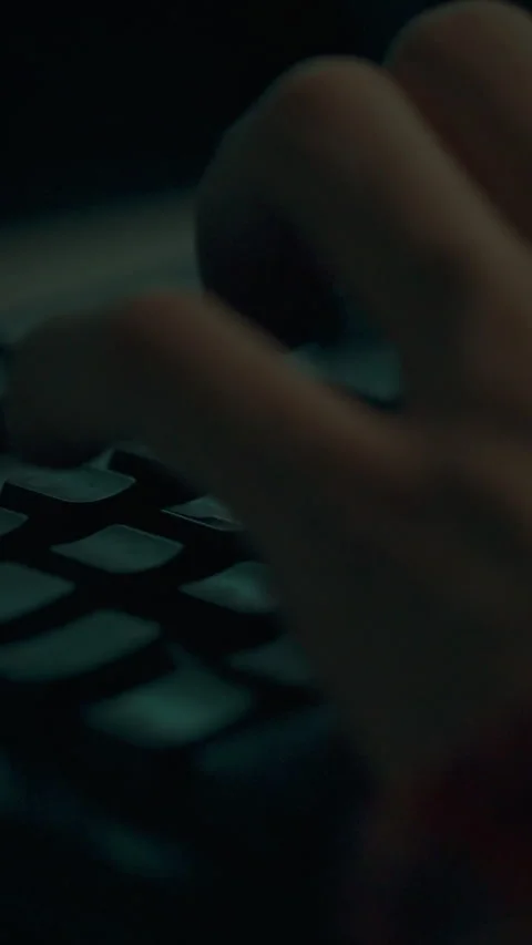 Fingers typing on a dark keyboard during late night work session with a focu Stock Footage 331582382