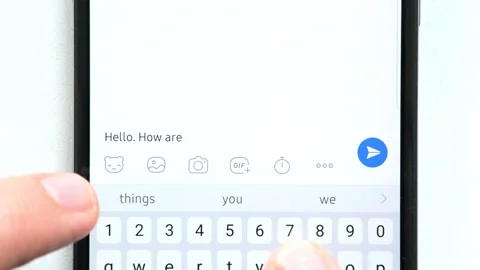 Fingers write the message "How are you doing?" on the phone screen. and receives Stockbeeldmateriaal 248028817