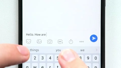 Fingers write the message "How are you doing?" on the phone screen. and receives Stock-Footage 248028845