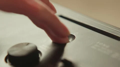 Fingertip pressing circular recess on electronic control panel beside rotary Stock-Footage 345655629
