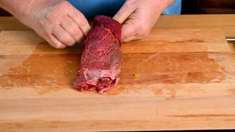 The finished beef roulade is covered, rolled up and fixed with wooden sticks. Stock Footage 123583718