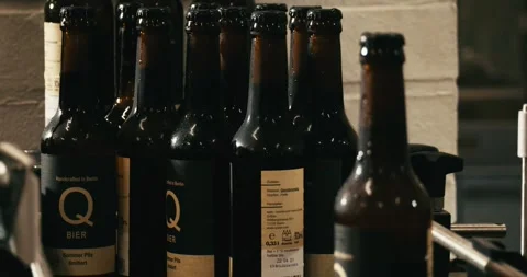 Finished beer bottles at end of conveyor belt in Berlin brewery July 2020 Stock Footage 335142491