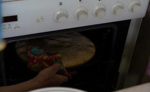 The finished cake is pulled out of the oven Stock Photos
