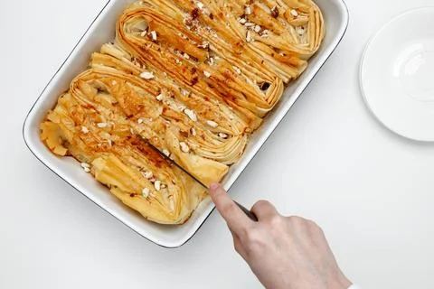 Finished Crinkle Cake made from phyllo dough is cut with a knife Stock Photos