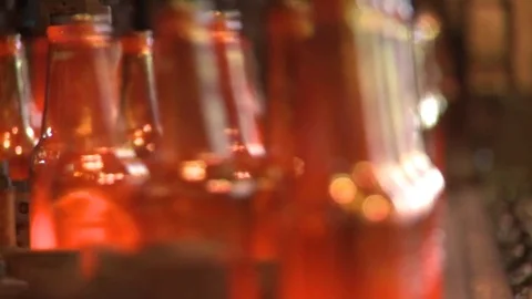 Finished glass beer bottles incandescent in production line slow motion Stock Footage