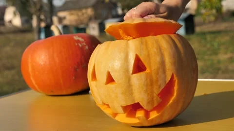 Finished Halloween pumpkin on the table gets its hat. jack lantern ready 스톡 동영상 253224613