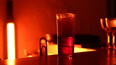 Finished Long Drink Cocktail in Dramatic Orange Bar Light Stock Footage 318001957