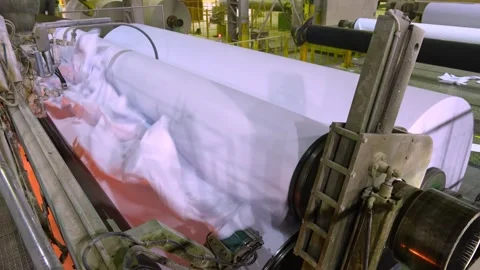 The finished paper in the roll comes out of the paper machine. Paper production Stockbeeldmateriaal 301467406