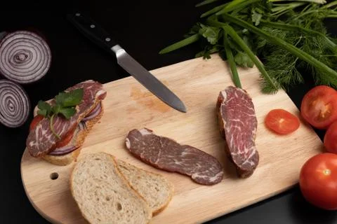 The finished sandwich on the kitchen Board with different ingredients Stock Photos
