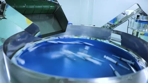 The finished syringes fall onto the circular distribution line and move alon Stock Footage 163088188