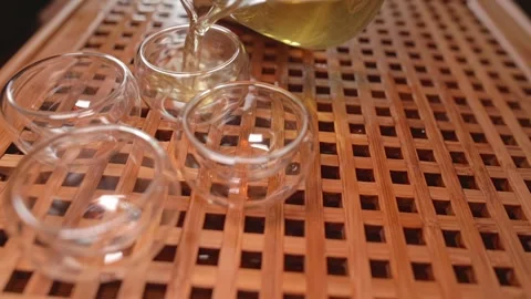 The finished tea is poured into small Chinese drinking bowls standing on a tea Stock Footage 264400724
