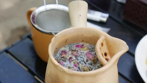 The finished tea rests in its pot, petals floating on top, evoking a sense of Stock Footage 312108917
