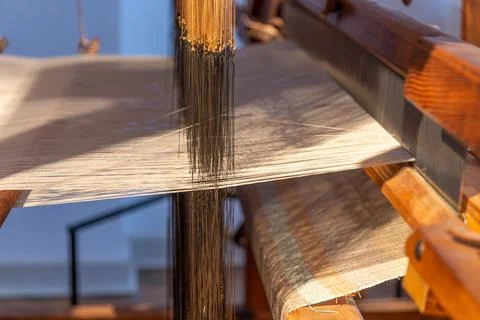 Finished textile rolling on loom beam in craft workshop setting Stock Photos