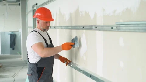 Finishing and Patching Drywall Walls by Caucasian Remodeler in His 45s Vídeos de archivo 245549837