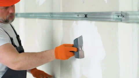Finishing and Patching Drywall Walls by Caucasian Remodeler in His 45s Vídeos de archivo 245550536