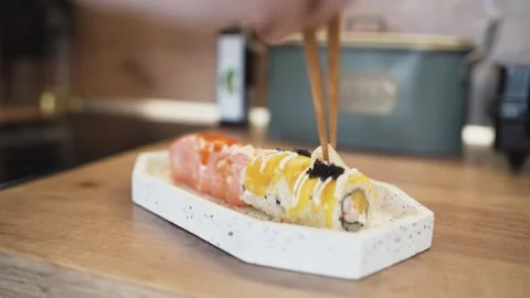 Finishing Touch: Hand Adds Ginger on Top of Sushi During Home Cooking Session in Stock Footage 306651651