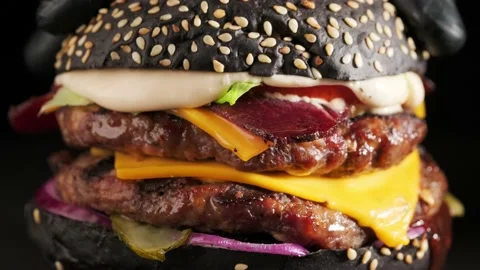 Finishing touch, making a burger. Close up shot of black tasty burger, fast food 스톡 동영상 147098819