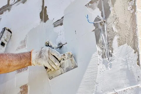 Finishing work on cladding of facade of house, construction worker applies .. 写真素材