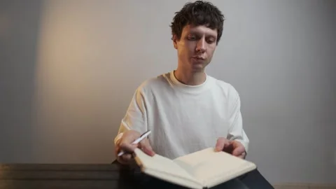 Finishing writing session and closing notebook with calm focus Stock-Footage 322624752