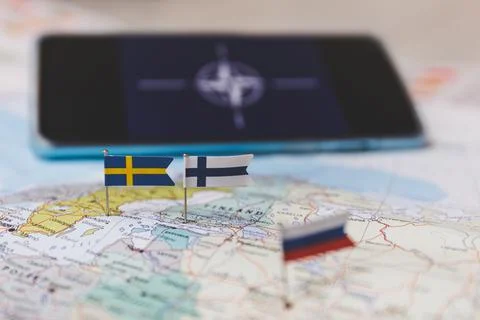 Finland and Sweden and Russian flags on Europe map. NATO flag in background Stock Photos
