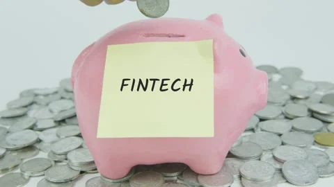 Fintech Word Or Text on Yellow Note Paper and Hand Inserting Coins Stock Footage 301506419