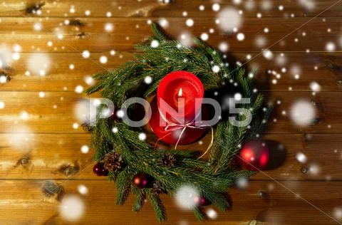 Fir branch wreath with candle on wooden table Stock Photos