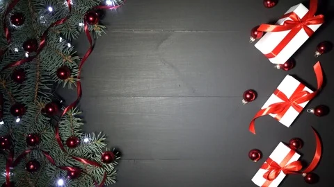 Fir branches adorned with xmas baubles, lights and white gifts with red ribbon 스톡 동영상 99062404